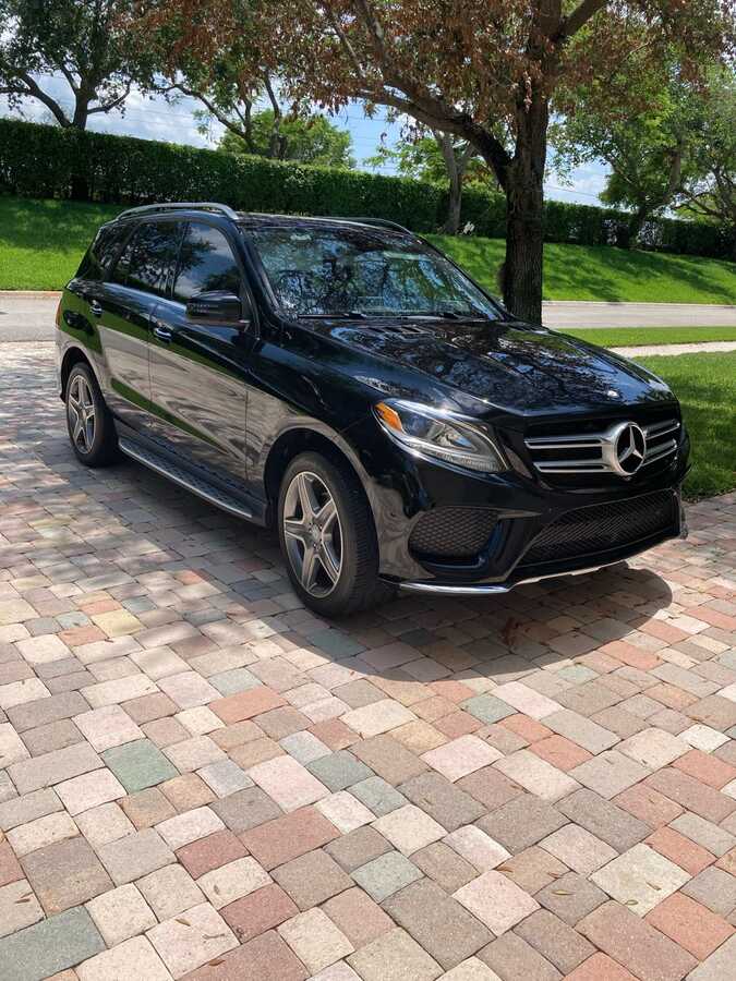 Freshly detailed black Mercedes SUV shining in a driveway